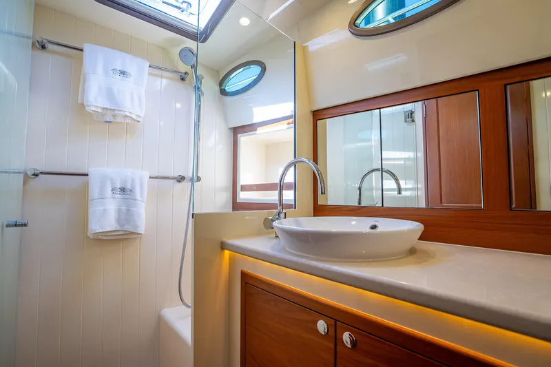 Miller Time Yacht Photos Pics Luxurious bathroom in 2017 Palm Beach Motor Yachts PB45, featuring elegant fixtures and wood accents.