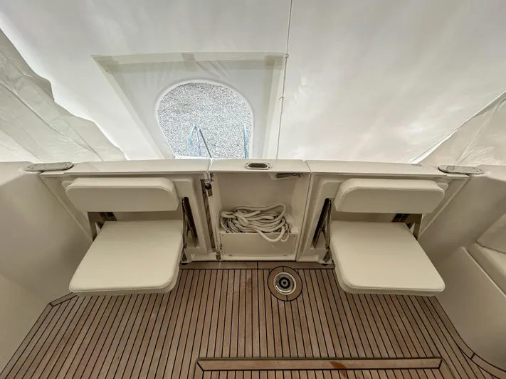  Yacht Photos Pics 2023 Beneteau Swift Trawler 35 interior with foldable seats and wooden flooring.
