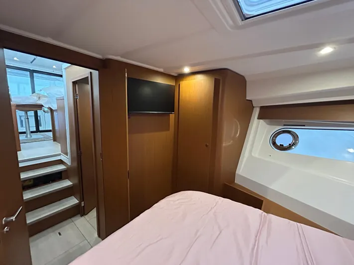  Yacht Photos Pics Interior of 2023 Beneteau Swift Trawler 35, featuring cozy cabin with TV and porthole.
