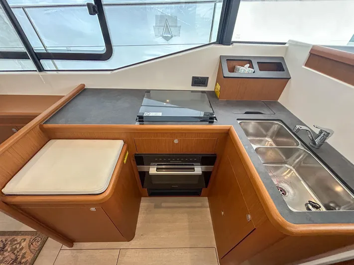  Yacht Photos Pics Modern kitchen in 2023 Beneteau Swift Trawler 35 with stove, sink, and wood cabinetry.