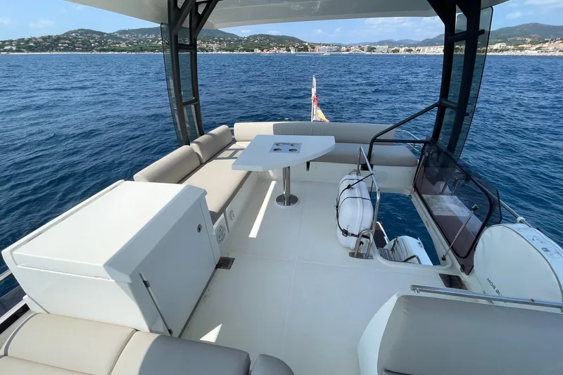  Yacht Photos Pics Luxurious 2021 Prestige 460 yacht deck with seating, table, and scenic ocean view.