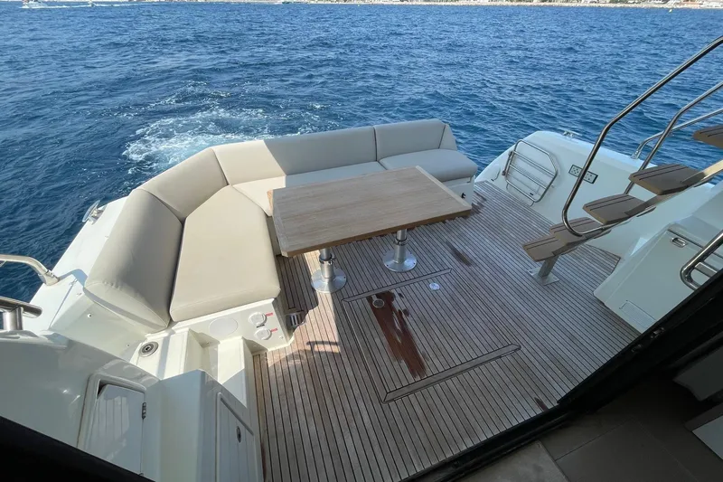  Yacht Photos Pics Luxurious 2021 Prestige 460 yacht deck with seating, table, and ocean view.