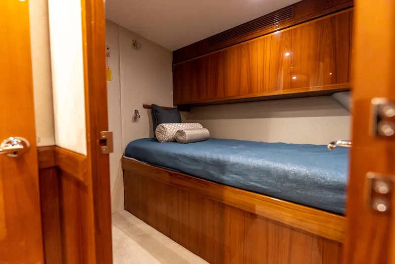 Resilient Yacht Photos Pics Luxurious cabin interior of 2018 Hatteras GT70 yacht with wooden finishes and cozy bedding.