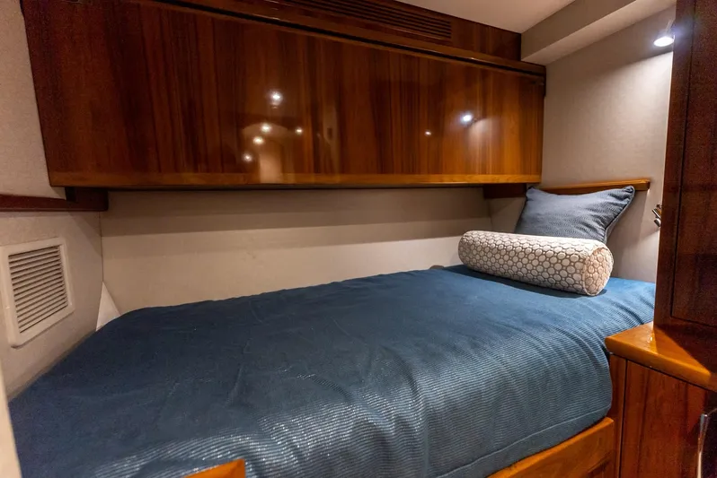 Resilient Yacht Photos Pics 2018 Hatteras GT70 yacht cabin with wooden cabinetry and blue bedding.