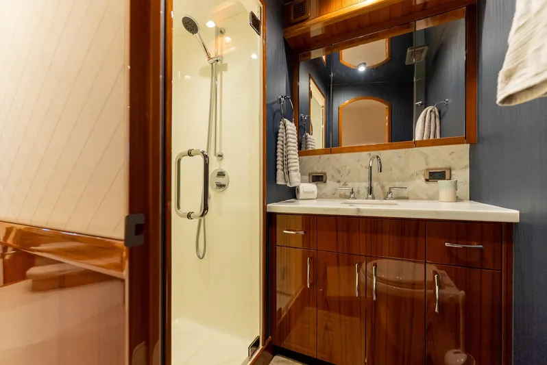 Resilient Yacht Photos Pics Luxurious bathroom in 2018 Hatteras GT70 yacht with wood cabinetry and glass shower.