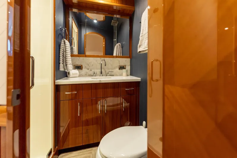 Resilient Yacht Photos Pics Luxurious bathroom in 2018 Hatteras GT70 yacht with wooden cabinetry and marble countertop.