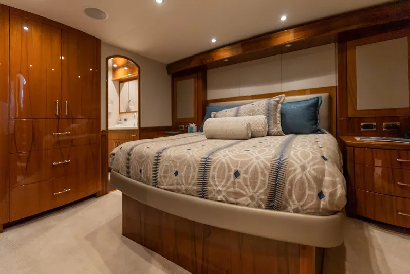 Resilient Yacht Photos Pics Luxurious bedroom interior of 2018 Hatteras GT70 yacht with elegant wood finishes and plush bedding.
