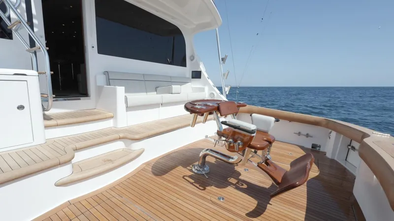 Resilient Yacht Photos Pics 2018 Hatteras GT70 yacht deck with fishing chair, ocean view, and wooden flooring.