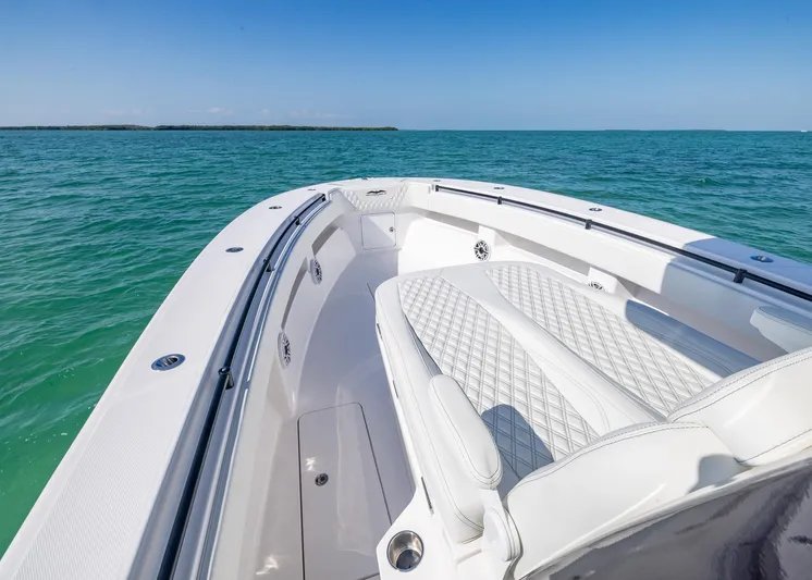  Yacht Photos Pics 2025 Invincible 36 Open Fisherman boat on turquoise water, featuring luxurious seating and sleek design.