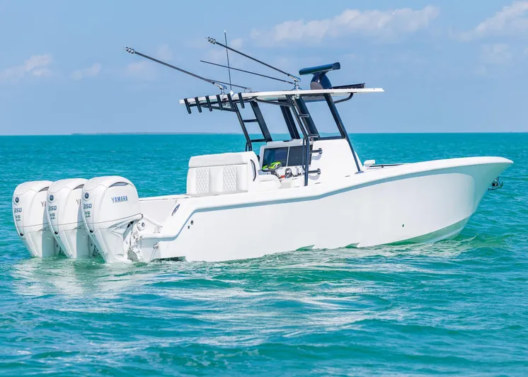  Yacht Photos Pics 2025 Invincible 36 Open Fisherman boat on turquoise water, featuring triple Yamaha engines.