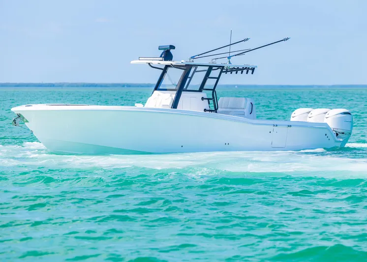  Yacht Photos Pics 2025 Invincible 36 Open Fisherman boat cruising on turquoise waters.