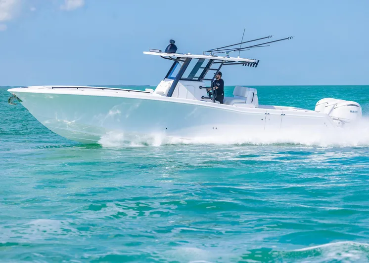  Yacht Photos Pics 2025 Invincible 36 Open Fisherman boat cruising on clear blue water.