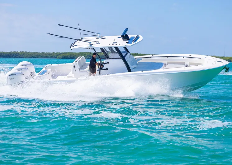  Yacht Photos Pics 2025 Invincible 36 Open Fisherman boat cruising on clear blue water.