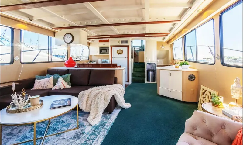 The West Star Yacht Photos Pics Luxurious 1994 Shaw 57 yacht interior with cozy seating, modern decor, and large windows.