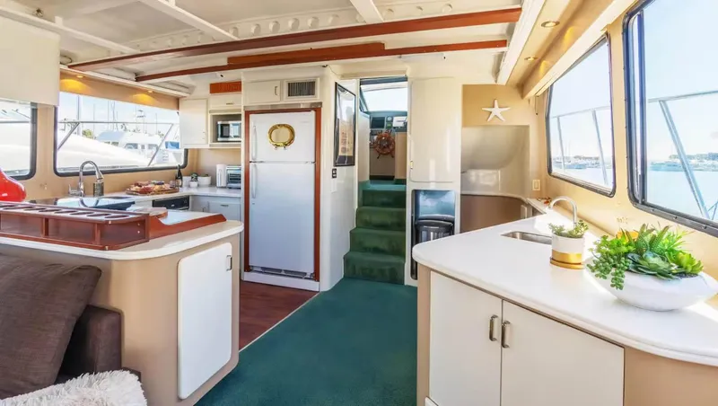 The West Star Yacht Photos Pics Luxurious interior of a 1994 Shaw 57 yacht with modern kitchen and seating area.