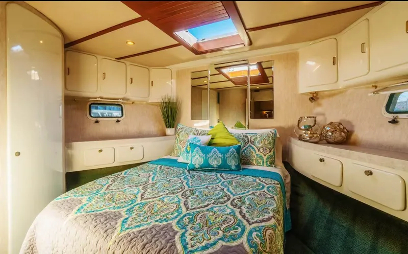 The West Star Yacht Photos Pics Luxurious 1994 Shaw 57 yacht bedroom with elegant bedding and ample storage.