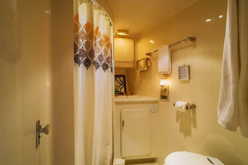 The West Star Yacht Photos Pics Compact bathroom in a 1994 Shaw 57 boat, featuring a shower, sink, and towel rack.