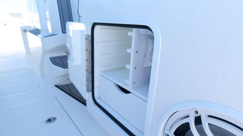 Engine Warranty X Trailer Yacht Photos Pics Open storage compartment on 2020 Invincible 37 Catamaran, showcasing interior shelves and speaker.