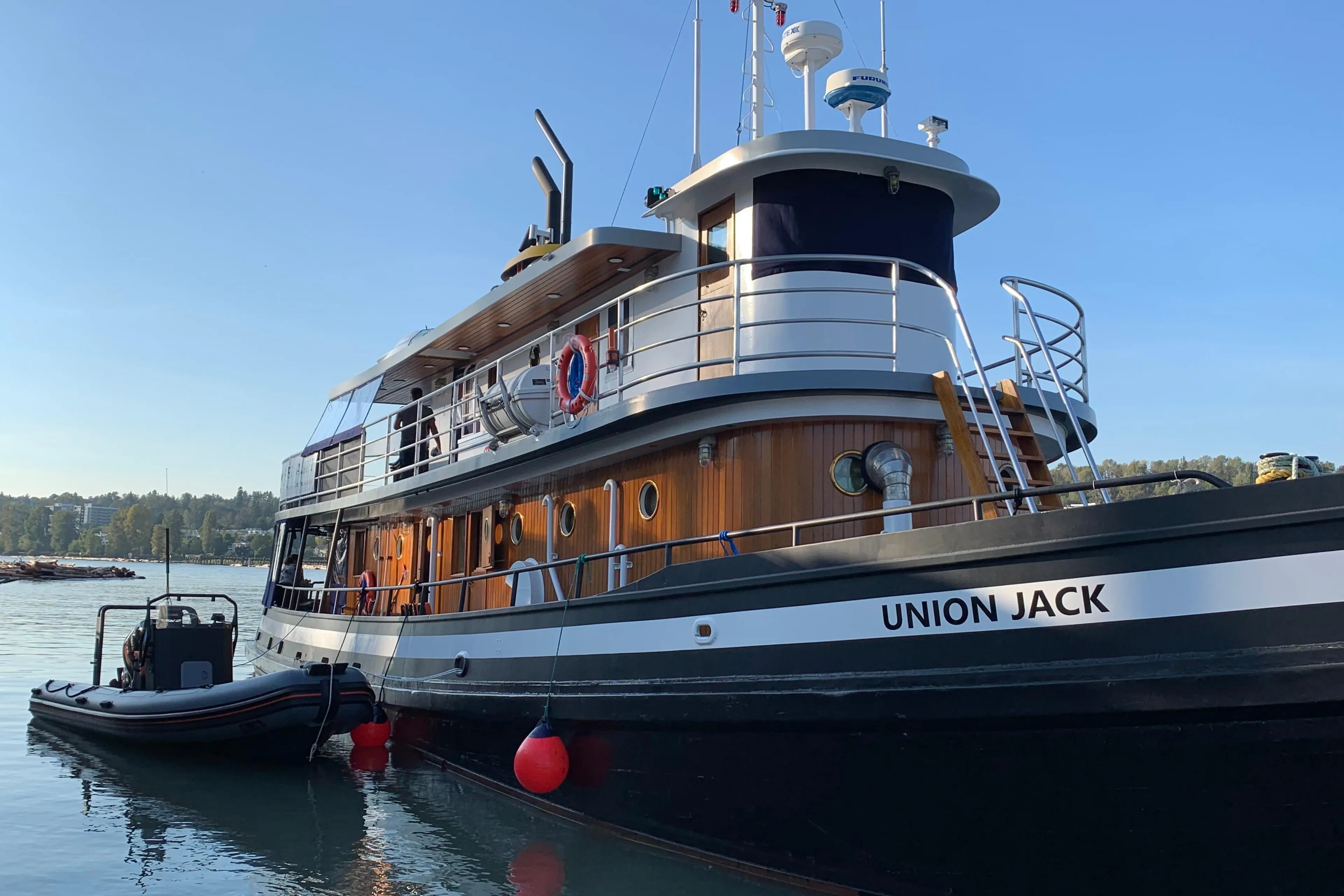 Historic 1941 McKenzie Barge tugboat "Union Jack" docked on calm water.