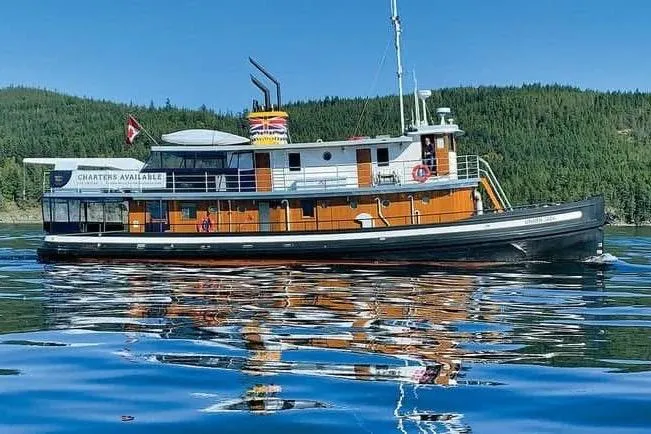 Vintage 1941 McKenzie Barge & Derrick Co. Ltd tugboat on serene water, charters available.