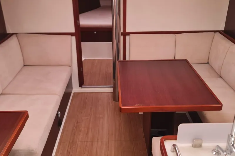  Yacht Photos Pics Interior of 2010 Hanse 400e yacht with wooden table and beige seating.
