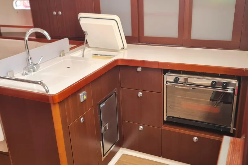  Yacht Photos Pics Modern kitchen in 2010 Hanse 400e yacht with sink, oven, and wooden cabinetry.
