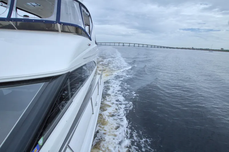 Why Knot Yacht Photos Pics 2013 Meridian 441 Sedan cruising on open water with bridge in background.