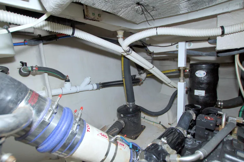 Why Knot Yacht Photos Pics Engine room of a 2013 Meridian 441 Sedan yacht, showcasing pipes and mechanical components.