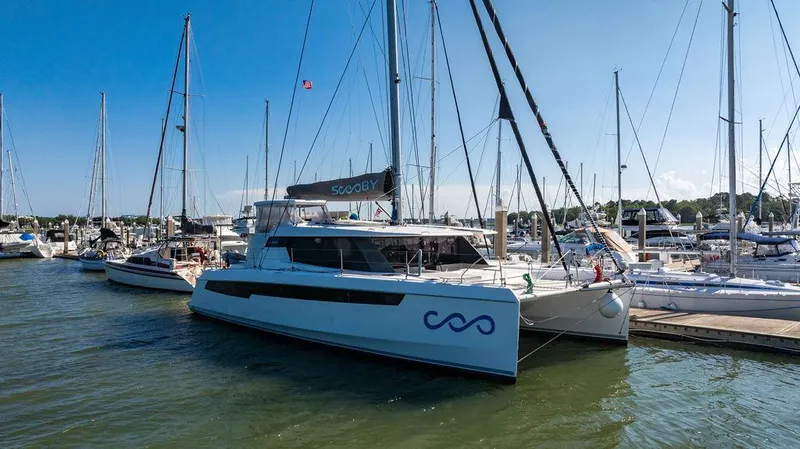 Scooby Yacht Photos Pics 2022 Leopard 50 catamaran docked at marina under clear blue sky.