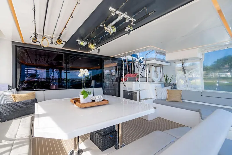 Scooby Yacht Photos Pics Luxurious 2022 Leopard 50 yacht interior with fishing rods, dining area, and modern decor.