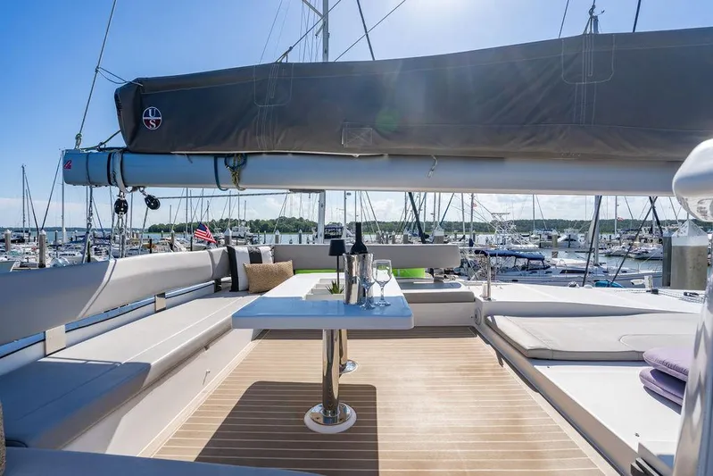 Scooby Yacht Photos Pics Luxurious 2022 Leopard 50 yacht deck with seating, table, and marina view.
