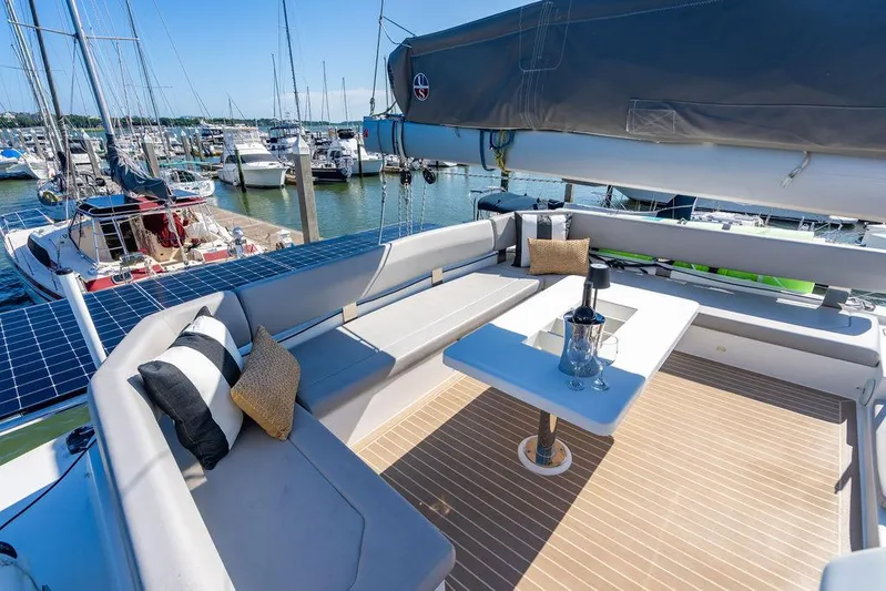 Scooby Yacht Photos Pics Luxurious 2022 Leopard 50 yacht deck with seating, table, and marina view.