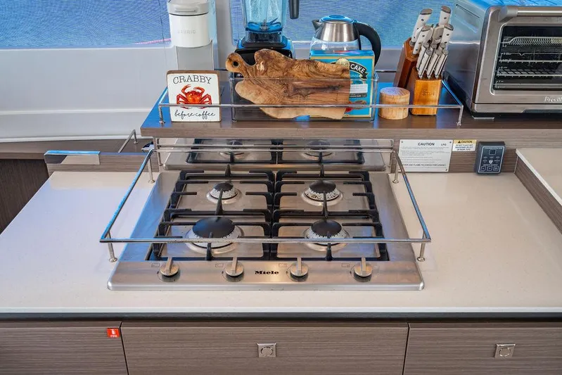 Scooby Yacht Photos Pics Modern kitchen with Miele gas stove, cutting board, and toaster oven on Leopard 50 yacht.
