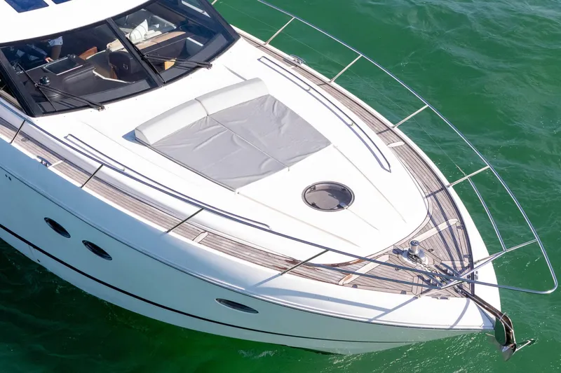 Luna Yacht Photos Pics Luxurious 2009 Princess V62 yacht on clear green water, featuring sleek design and spacious deck.