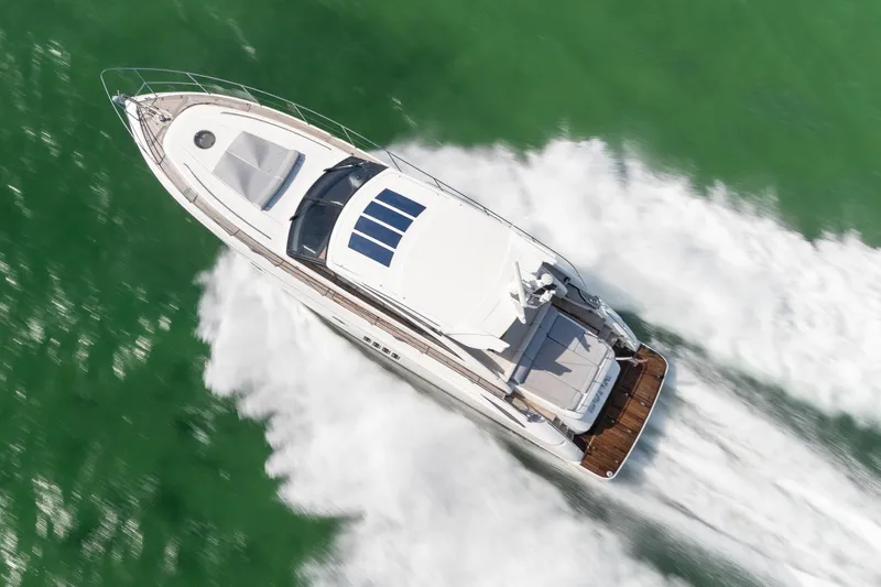 Luna Yacht Photos Pics Aerial view of 2009 Princess V62 yacht cruising on green water.