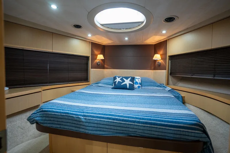 Luna Yacht Photos Pics Luxurious 2009 Princess V62 yacht bedroom with blue bedding and elegant lighting.