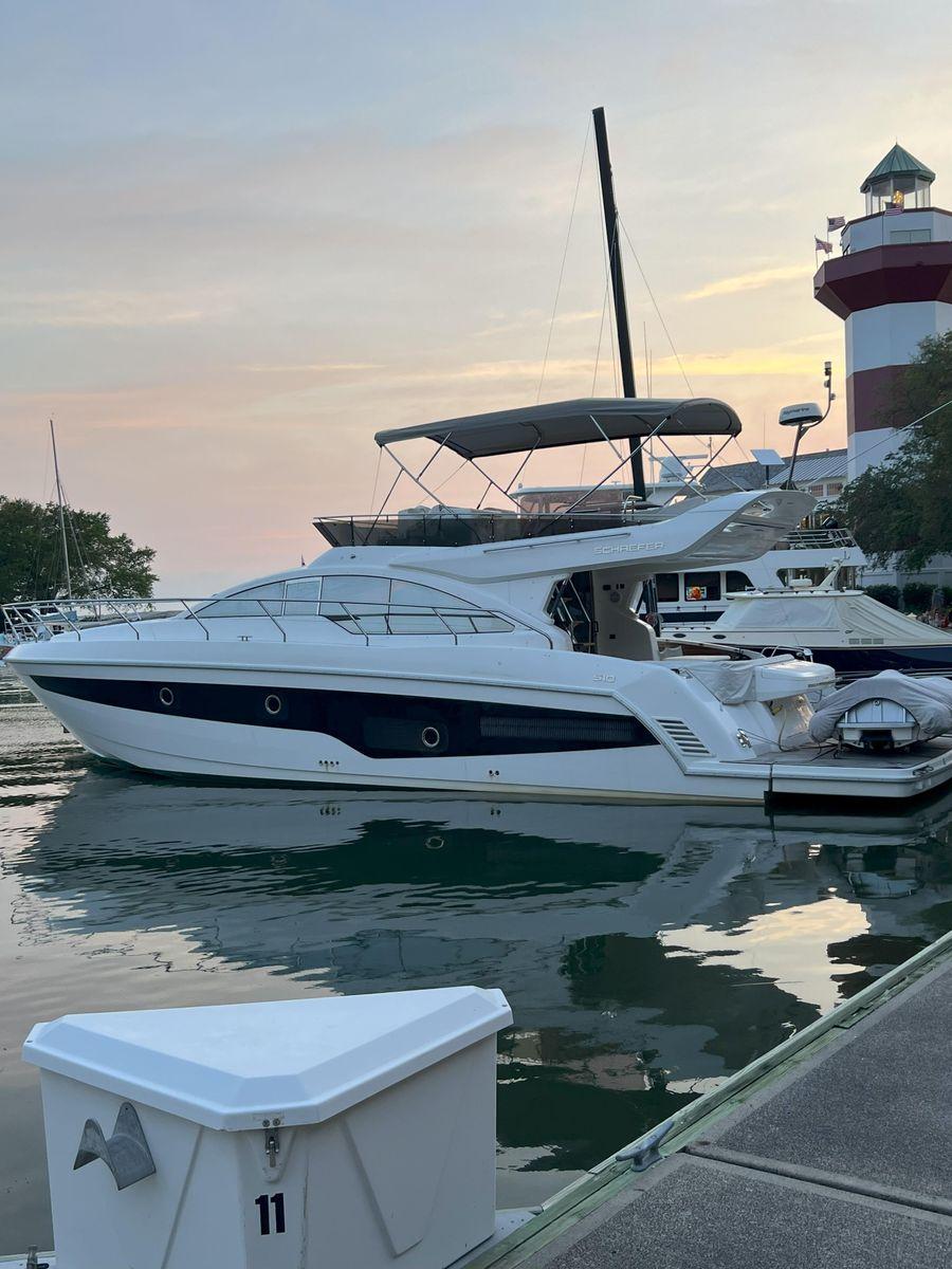 2019 Schaefer 510 yacht docked near a lighthouse at sunset.