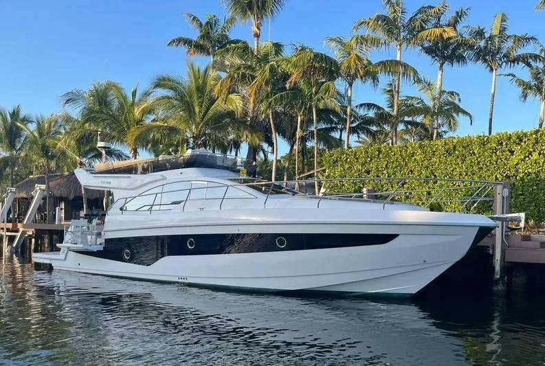 510 Schaefer Yacht Photos Pics 2019 Schaefer 510 yacht docked by palm trees, reflecting on calm water.