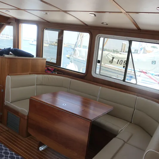 Whirlaway Yacht Photos Pics Interior of 2020 Alden Motor Yacht with elegant seating and wooden table.
