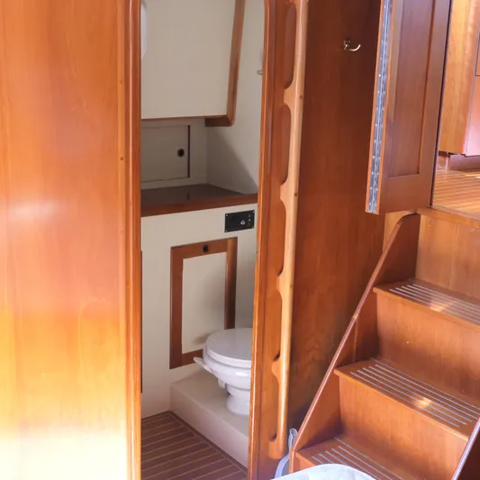 Whirlaway Yacht Photos Pics Interior of 2020 Alden Motor Yacht showing wooden stairs and compact bathroom.
