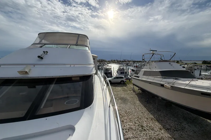  Yacht Photos Pics 2003 Carver 564 Cockpit Motor Yacht docked at marina under cloudy sky.