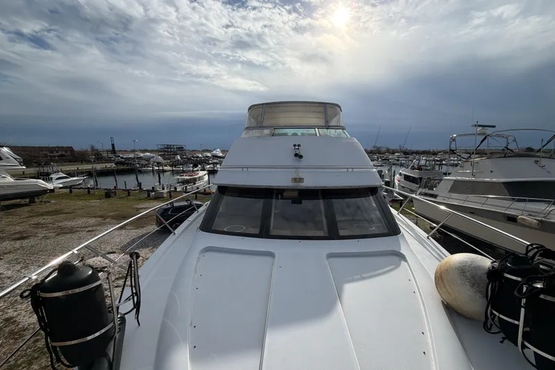  Yacht Photos Pics 2003 Carver 564 Cockpit Motor Yacht docked at marina under cloudy sky.