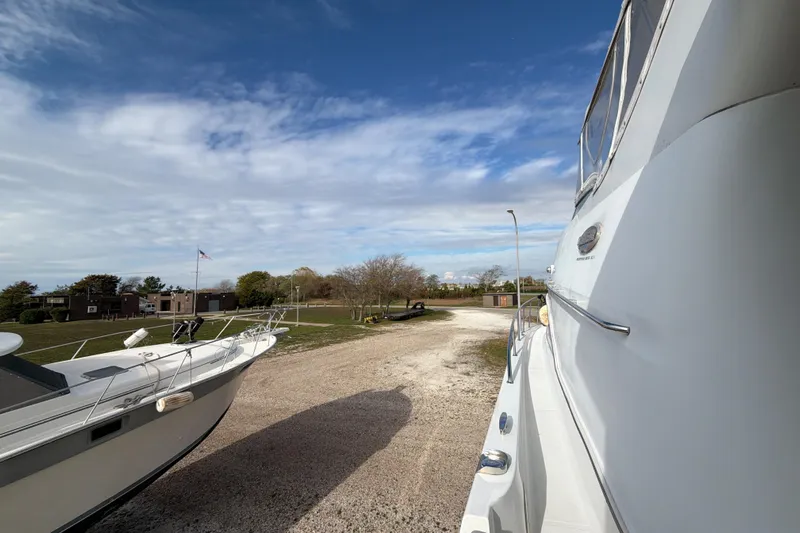  Yacht Photos Pics 2003 Carver 564 Cockpit Motor Yacht on a sunny day, docked on gravel.