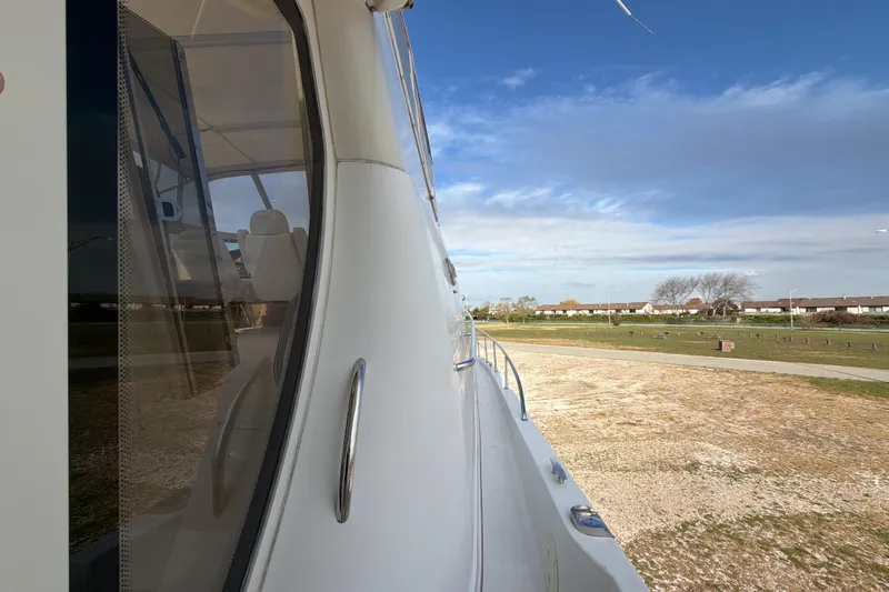  Yacht Photos Pics 2003 Carver 564 Cockpit Motor Yacht side view with clear sky and grassy landscape.
