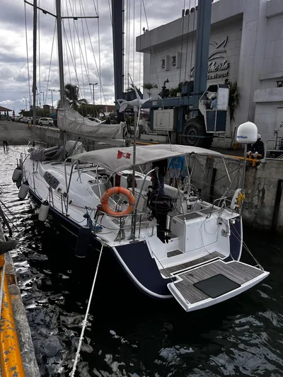 Rejoyce Yacht Photos Pics Sailing yacht Beneteau Oceanis 54, 2010 model, docked at a marina with overcast skies.