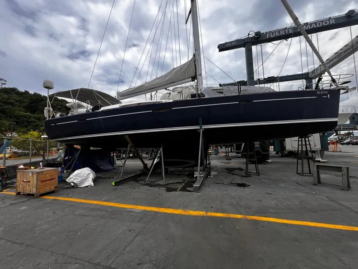 Rejoyce Yacht Photos Pics 2010 Beneteau Oceanis 54 sailboat on dry dock, undergoing maintenance under cloudy skies.