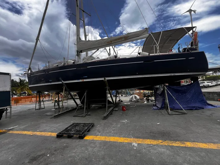 Rejoyce Yacht Photos Pics Beneteau Oceanis 54 sailboat from 2010 on dry dock under a cloudy sky.