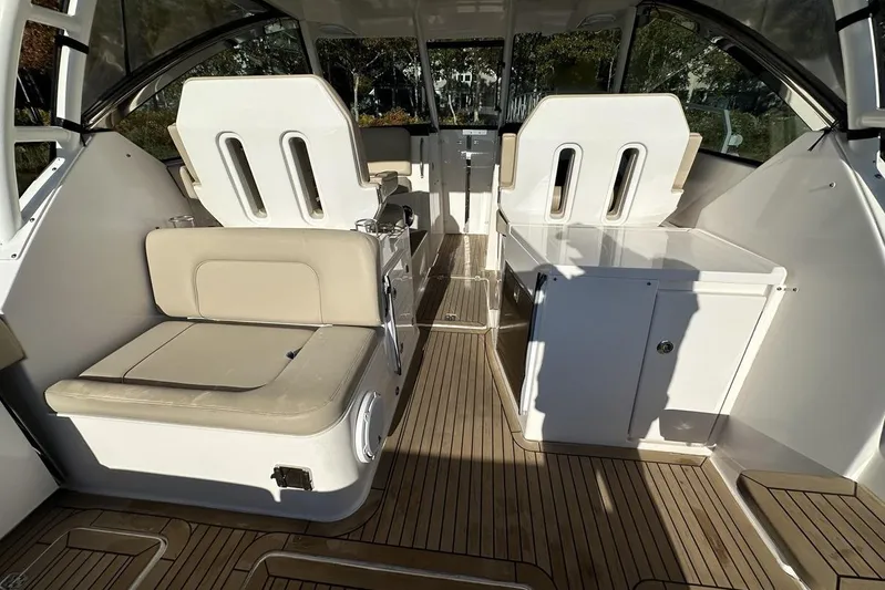 Soul Mates Yacht Photos Pics 2016 Pursuit DC 325 Dual Console interior with beige seating and wooden flooring.