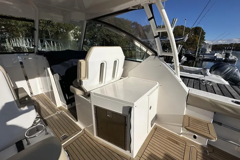 Soul Mates Yacht Photos Pics 2016 Pursuit DC 325 Dual Console boat interior with seating and storage, docked by the water.