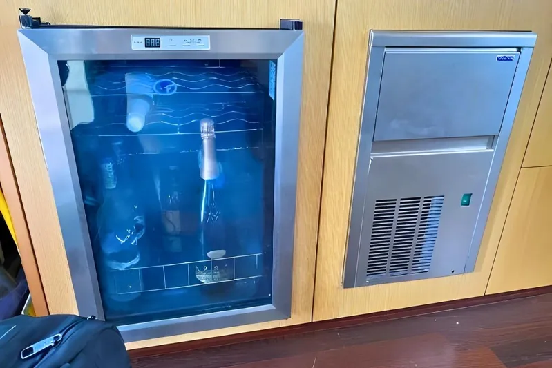  Yacht Photos Pics Wine cooler and ice maker on 2005 Ferretti Yachts 550, featuring sleek wood paneling.